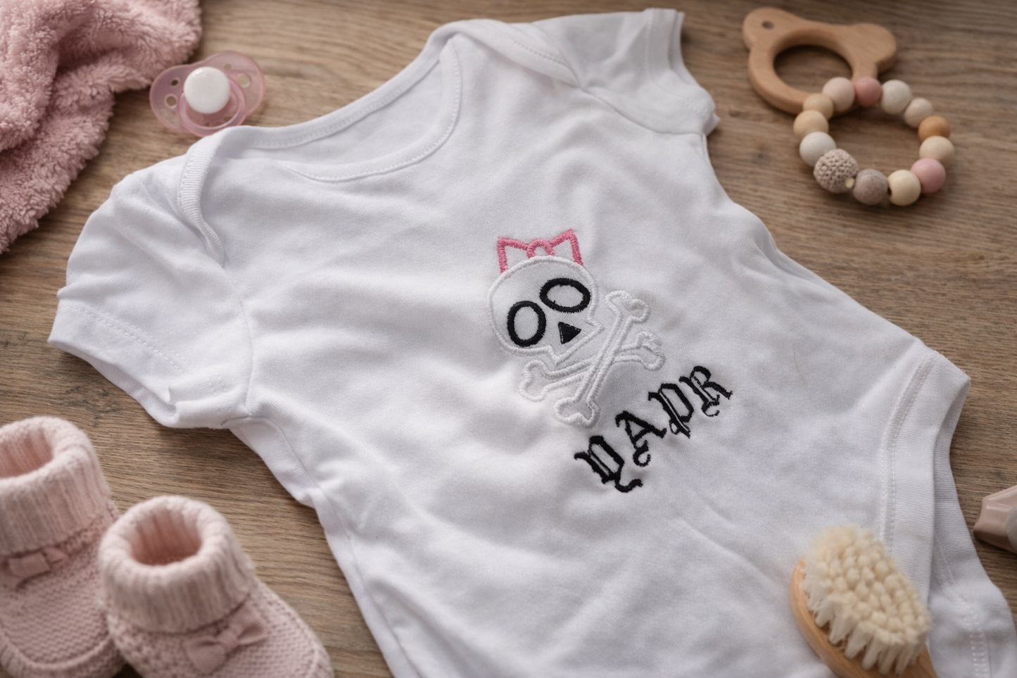 Personalised skull bow embroidered baby grow by Rebel Needleworks - gothic alternative baby gift UK