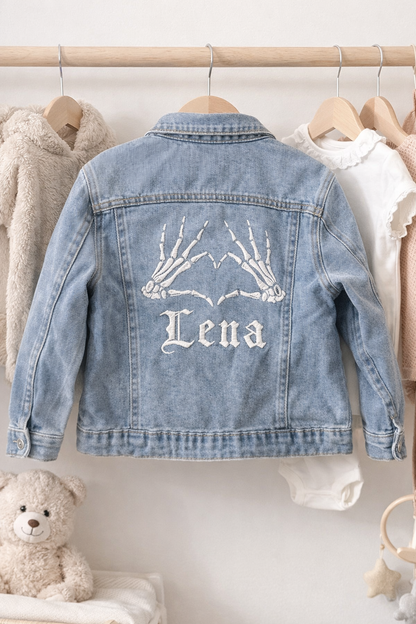 Denim jacket with 'Lena' embroidery on a hanger against a neutral background