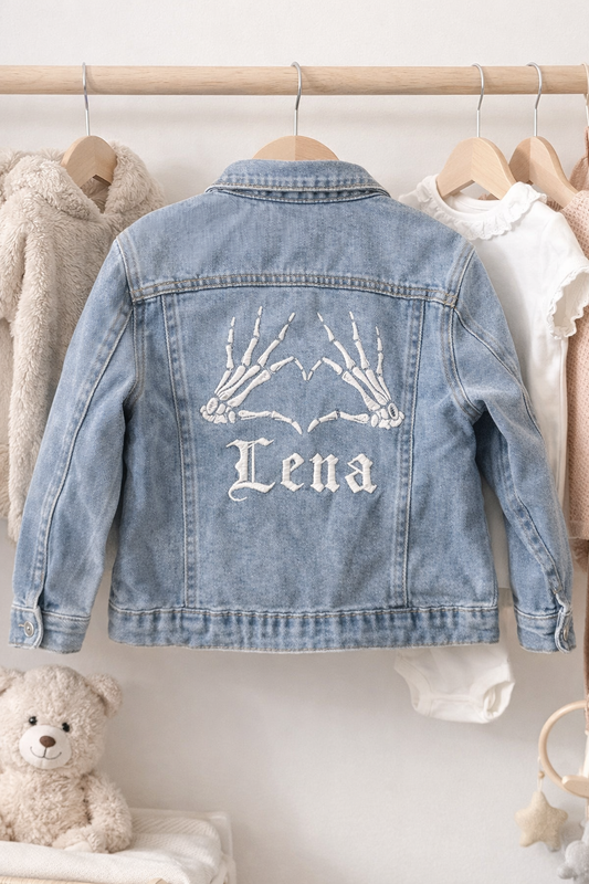 Denim jacket with 'Lena' embroidery on a hanger against a neutral background