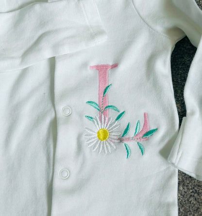 Custom pink daisy monogram embroidered sleepsuit by Rebel Needleworks - personalised baby gift UK