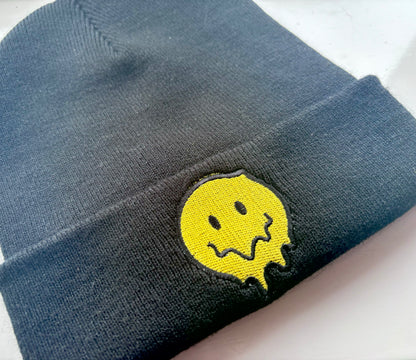 Melting smiley face embroidered cuffed beanie hat by Rebel Needleworks - alternative fun hat UK