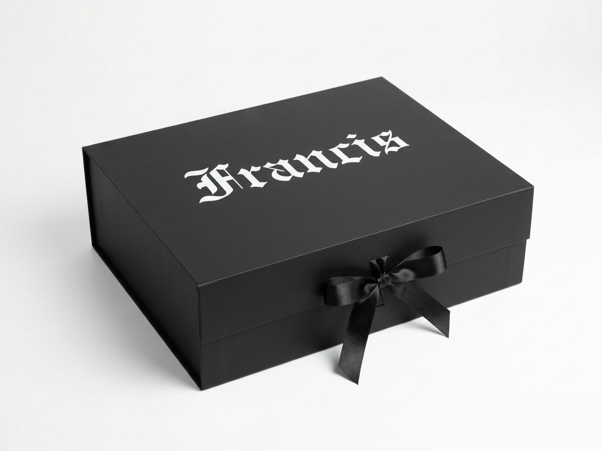 A black rectangular presentation box with the name 'Francis' printed in a white gothic font on the lid and a black ribbon tied in a bow on the front, photographed on a light gray background.