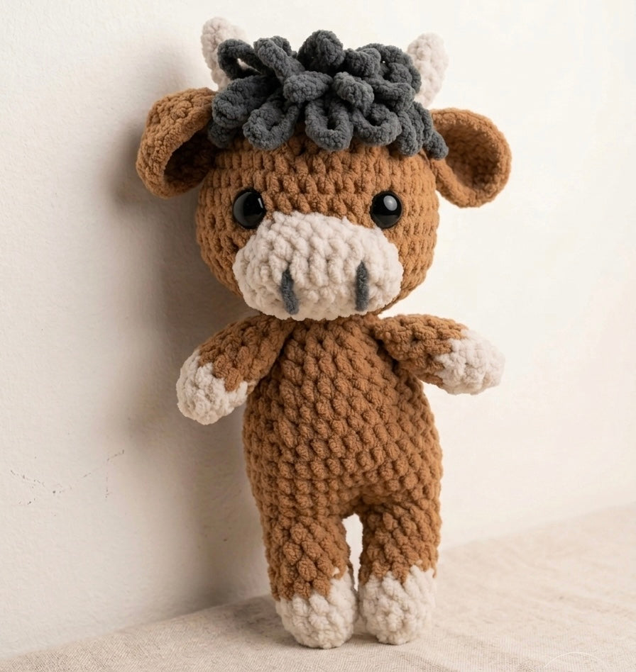 Crocheted highland cow plush with a white background