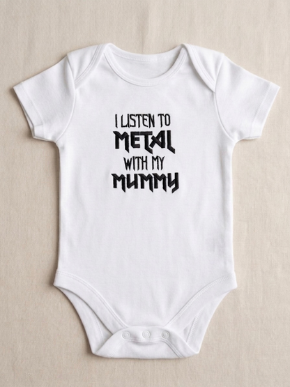 A white short-sleeve baby bodysuit with black embroidered text reading 'I LISTEN TO METAL WITH MY MUMMY' printed on the chest, laid flat on a light beige textured background.