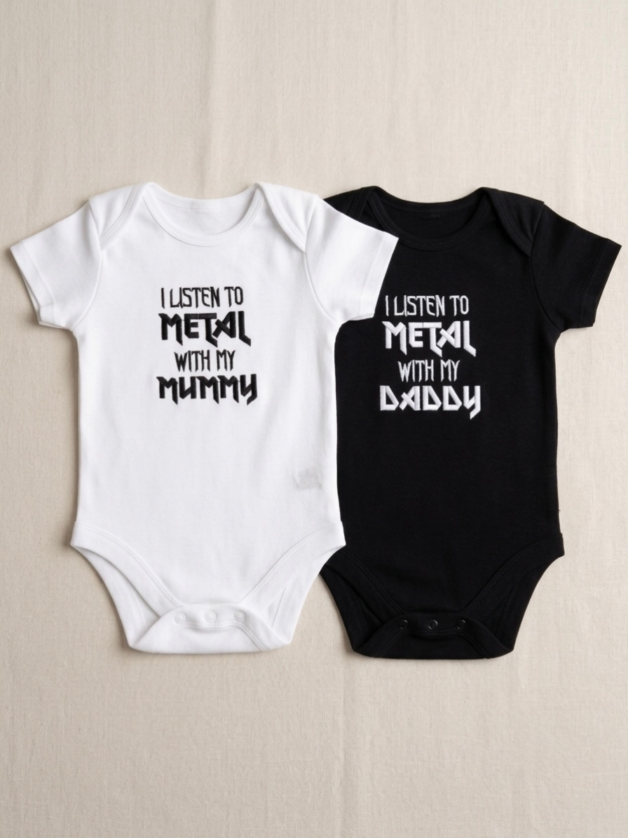 Two baby short-sleeve bodysuits laid flat on a light beige background: one white with black embroidered text reading 'I LISTEN TO METAL WITH MY MUMMY' and one black with white text reading 'I LISTEN TO METAL WITH MY DADDY'.